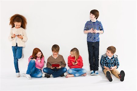 people lining up on white background - Children using different gadgets Stock Photo - Premium Royalty-Free, Code: 614-05818960