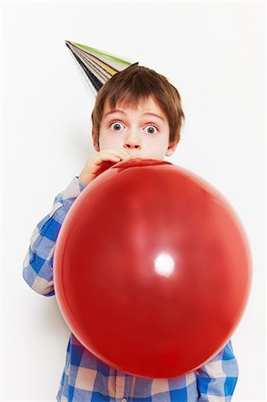 Boy blowing up balloon Stock Photo - Premium Royalty-Free, Code: 614-05819072