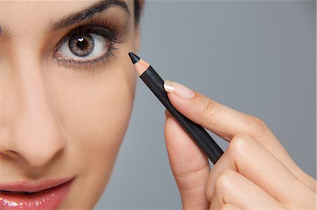 Beautiful woman applying eyeliner Stock Photo - Premium Royalty-Free, Code: 614-05955238