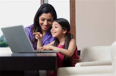 east indian mother and children - Mother and daughter having fun on a laptop Stock Photo - Premium Royalty-Free, Code: 614-05955292