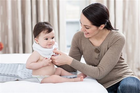 picture of a baby boy smiling - Mother dressing baby son Stock Photo - Premium Royalty-Free, Code: 614-05955660