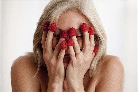 simsearch:614-06002409,k - Mature woman wearing raspberries on fingers and covering face Stock Photo - Premium Royalty-Free, Code: 614-06002291