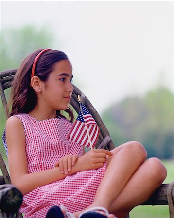 flag of usa picture - Girl sitting on porch holding US flag Stock Photo - Premium Royalty-Free, Code: 614-06002308