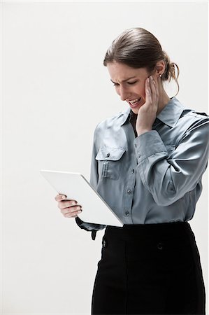 Young businesswoman using digital tablet, studio shot Stock Photo - Premium Royalty-Free, Code: 614-06002367