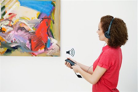 Young woman using audio guide in art gallery Stock Photo - Premium Royalty-Free, Code: 614-06044439