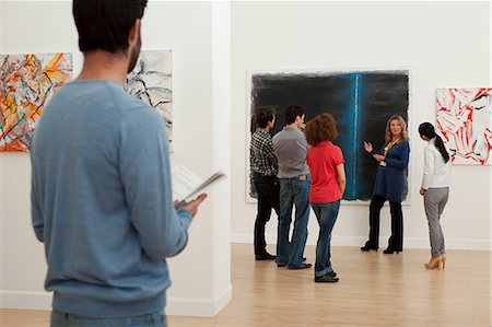 Men and women listening to guide in art gallery Foto de stock - Sin royalties Premium, Código: 614-06044457