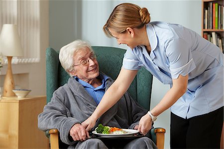 Carer bringing meal to senior man Stock Photo - Premium Royalty-Free, Code: 614-06043864