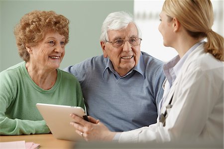 Doctor using digital tablet with senior couple Stock Photo - Premium Royalty-Free, Code: 614-06043871