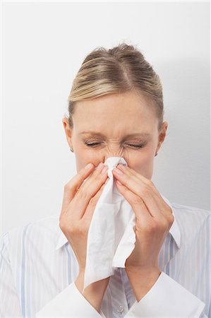 people kleenex - Mid adult woman blowing nose Stock Photo - Premium Royalty-Free, Code: 614-06043954