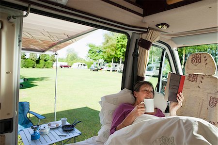 Mature woman reading in camper van Stock Photo - Premium Royalty-Free, Code: 614-06116104