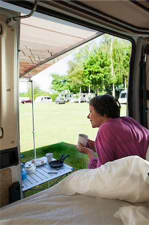 Mature woman drinking hot drink in camper van Stock Photo - Premium Royalty-Free, Code: 614-06116102