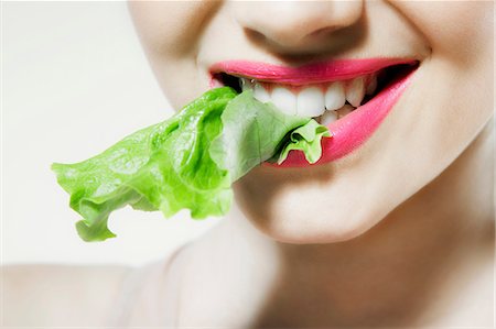 smile color eating - Young woman biting lettuce Stock Photo - Premium Royalty-Free, Code: 614-06116205