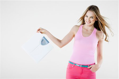 Young woman holding weight scales Stock Photo - Premium Royalty-Free, Code: 614-06116200