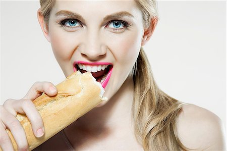 person eating alone - Young woman biting baguette Stock Photo - Premium Royalty-Free, Code: 614-06116225