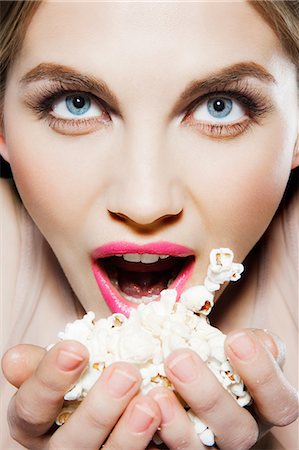 simsearch:614-06116210,k - Young woman eating popcorn Foto de stock - Sin royalties Premium, Código: 614-06116230