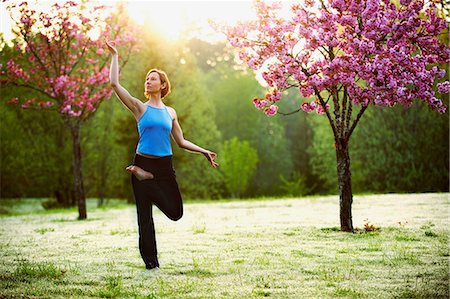sunny woman outside park - Woman in yoga pose in park Stock Photo - Premium Royalty-Free, Code: 614-06116387
