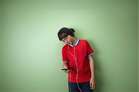 Boy listening to mp3 player Stock Photo - Premium Royalty-Free, Code: 614-06116439