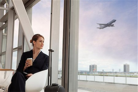 Businesswoman drinking coffee in airport Stock Photo - Premium Royalty-Free, Code: 614-06116501