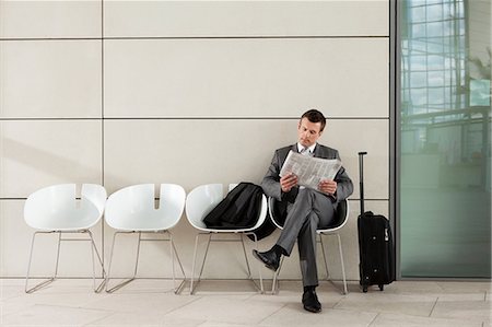 photos of people airport - Businessman reading newspaper Stock Photo - Premium Royalty-Free, Code: 614-06116543