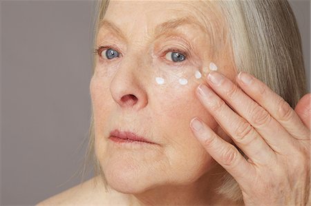 photos of 70 year old women faces - Senior woman applying eye cream Stock Photo - Premium Royalty-Free, Code: 614-06169261