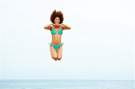 simsearch:649-08117852,k - Young woman in turquoise bikini jumping on beach Foto de stock - Sin royalties Premium, Código: 614-06169384