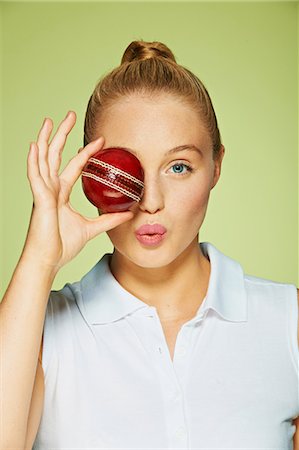 Young woman holding cricket ball over her eye Stock Photo - Premium Royalty-Free, Code: 614-06169516