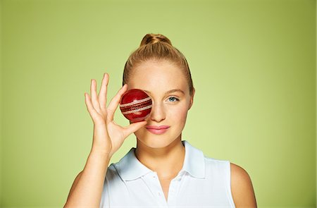 Young woman holding cricket ball over her eye Stock Photo - Premium Royalty-Free, Code: 614-06169523