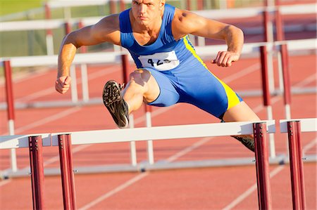 Male hurdler jumping over hurdle Stock Photo - Premium Royalty-Free, Code: 614-06311631