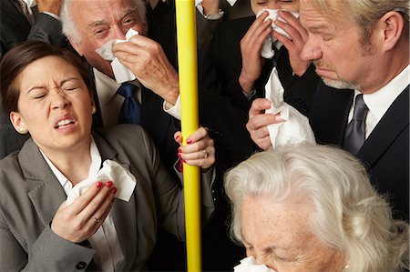 Businesspeople sneezing on subway train Stock Photo - Premium Royalty-Free, Code: 614-06311801