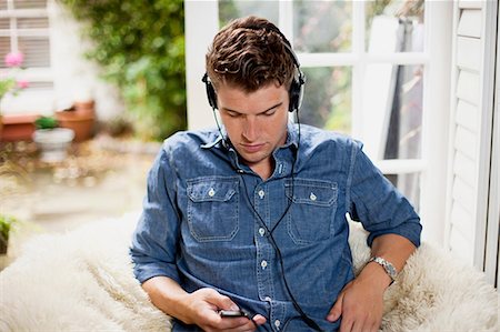 denim shirt - Young man wearing earphones Foto de stock - Sin royalties Premium, Código: 614-06336008