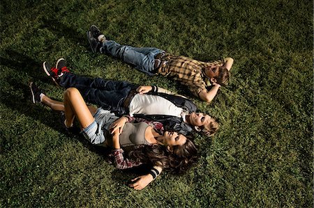 Couple and friend lying on grass at night, high angle Stock Photo - Premium Royalty-Free, Code: 614-06402584