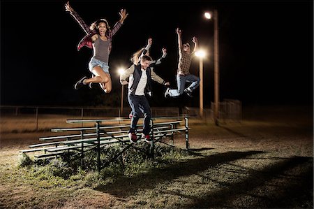 simsearch:614-06402677,k - Four friends jumping over bleachers at night Stock Photo - Premium Royalty-Free, Code: 614-06402602