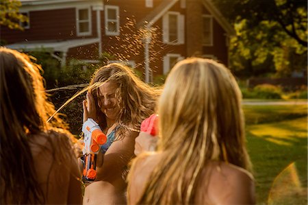 Girls having water fight with water pistols Stock Photo - Premium Royalty-Free, Code: 614-06402682