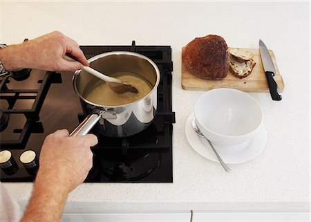 Man stirring saucepan of soup on hob Stock Photo - Premium Royalty-Free, Code: 614-06403004