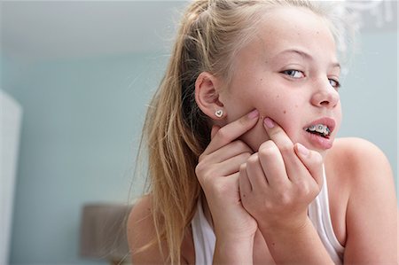 disgust - Teenage girl squeezing a spot Stock Photo - Premium Royalty-Free, Code: 614-06403058