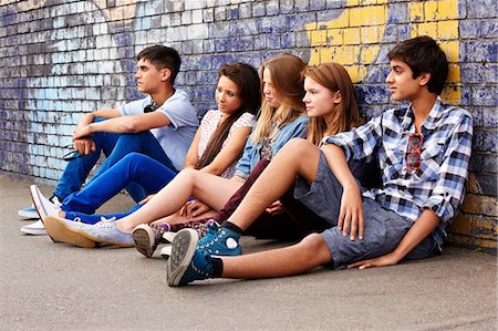 Teenagers sitting against a wall Stock Photo - Premium Royalty-Free, Code: 614-06403070
