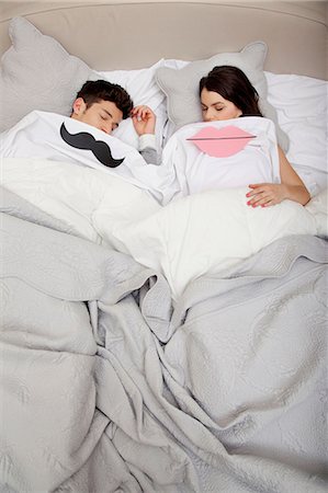 Couple in bed with lips and moustache Stock Photo - Premium Royalty-Free, Code: 614-06442402