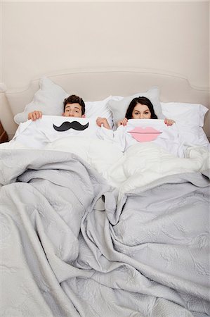 Couple in bed with lips and moustache Stock Photo - Premium Royalty-Free, Code: 614-06442440