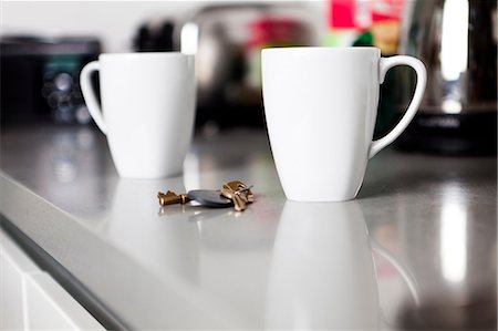 Two coffee mugs with keys on kitchen counter Stock Photo - Premium Royalty-Free, Code: 614-06442551