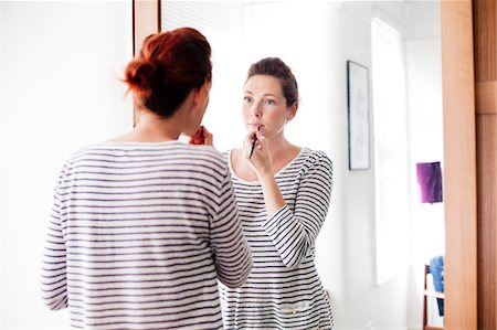 Woman applying make up Stock Photo - Premium Royalty-Free, Code: 614-06442578