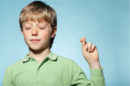 polo shirt - Boy with fingers crossed Stock Photo - Premium Royalty-Free, Code: 614-06442889