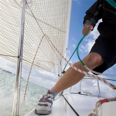 Man on yacht, pulling ropes Stock Photo - Premium Royalty-Free, Code: 614-06442927