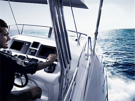 Man driving power boat Stock Photo - Premium Royalty-Free, Code: 614-06442928