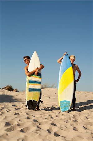 surfer - Two young men standing behind surfboards on beach Foto de stock - Sin royalties Premium, Código: 614-06443106