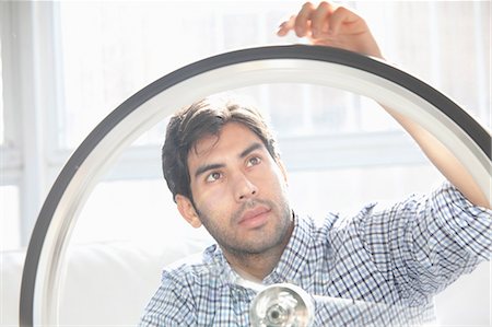 renovations man - Man fixing bicycle wheel indoors Stock Photo - Premium Royalty-Free, Code: 614-06536772