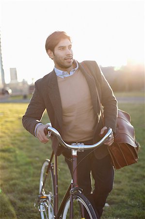 Man pushing bicycle in grass Foto de stock - Sin royalties Premium, Código: 614-06536819