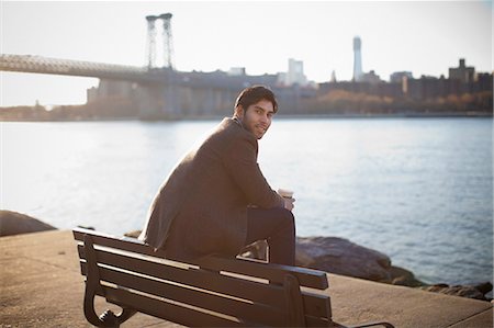 Smiling man sitting on park bench Stock Photo - Premium Royalty-Free, Code: 614-06536811