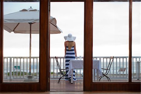 Woman standing on beachfront patio Foto de stock - Sin royalties Premium, Código: 614-06537219