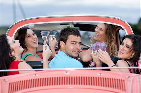 Friends toasting in convertible Stock Photo - Premium Royalty-Free, Code: 614-06537592