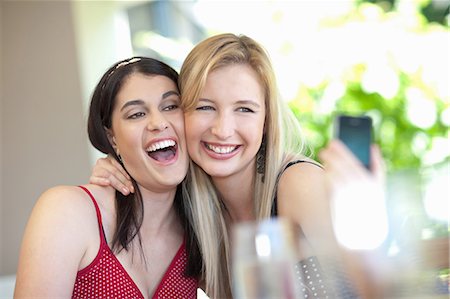 Smiling women taking pictures together Stock Photo - Premium Royalty-Free, Code: 614-06537610